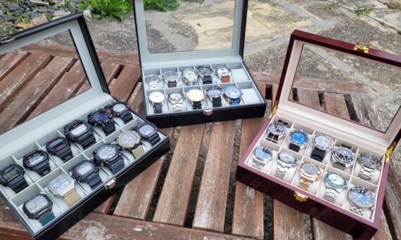 Three watch boxes, with watches in them.